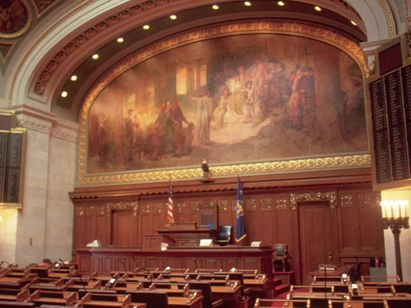 Wisconsin legislative sessions room facing the front of the room with the large mural above the leader's desk.