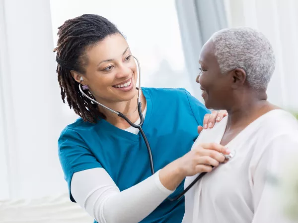 Nurse taking heart rate of patient