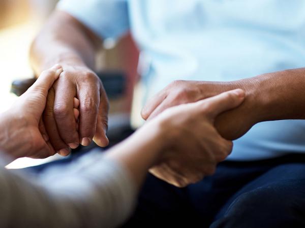 Helping hands to a seated person.