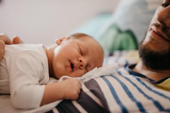 Man holding baby on chest