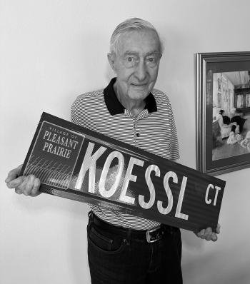 Wayne Koessl holding the street sign "KOESSL CT"